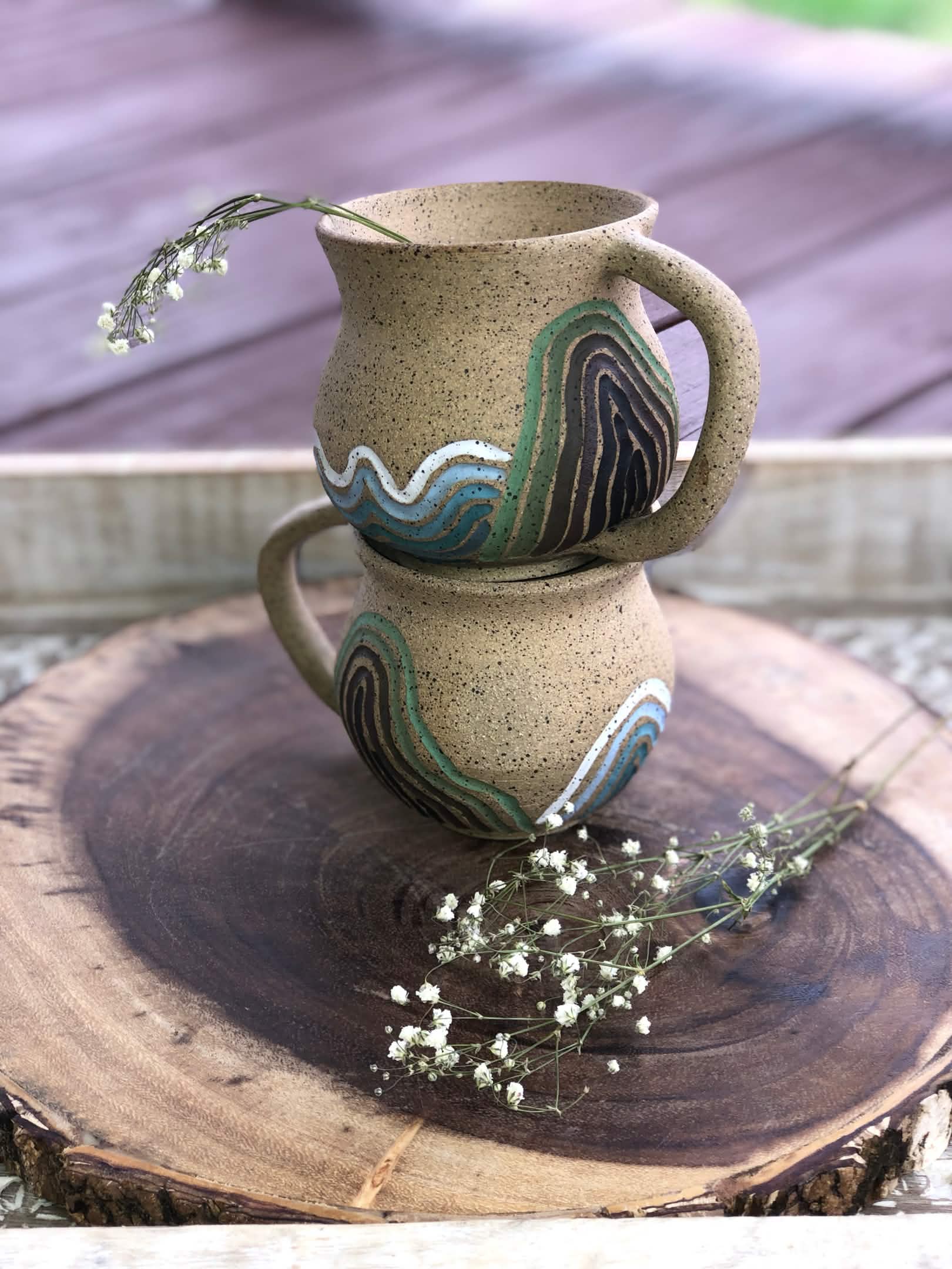 Two mugs with colorful carvings.